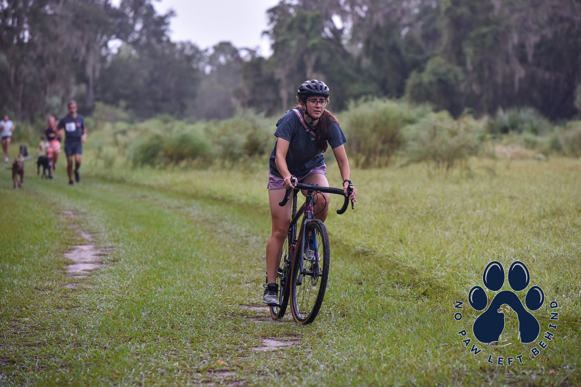 Woman riding bike at the PawFields 5k event, hosted by Disruptive Endeavors